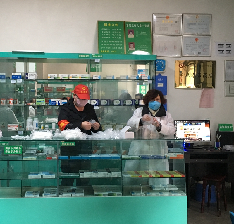 王建在藥店與工作人員分裝口罩 王建在藥店與工作人員分裝口罩